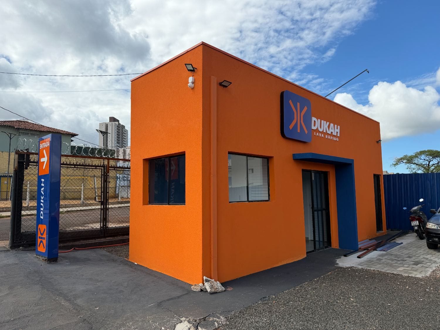 Fachada cube laranja com logo Dukah e placa Entrada